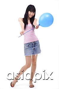 AsiaPix - Young woman holding a blue balloon towards camera