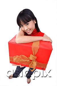 AsiaPix - Young woman holding big red gift box, portrait
