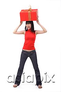 AsiaPix - Young woman balancing big red gift box on her head