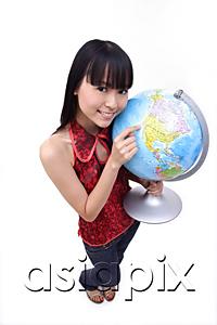 AsiaPix - Young woman holding and pointing at globe