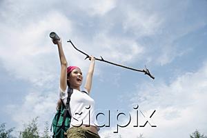 AsiaPix - Female hiker, holding hiking stick in air, smiling