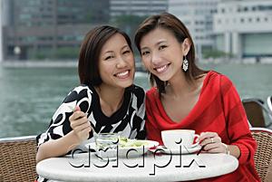AsiaPix - Two women at sidewalk cafe having lunch, smiling at camera