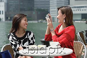 AsiaPix - Two women at outdoor cafe, using a camera