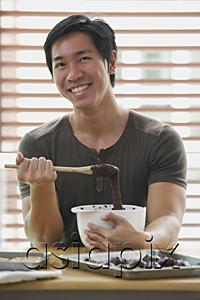 AsiaPix - Man in kitchen with mixing bowl