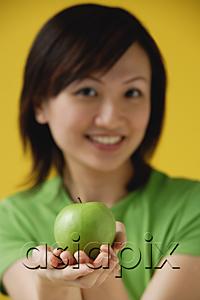 AsiaPix - Young woman holding apple  in cupped hands