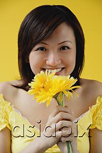 AsiaPix - Young woman holding yellow flowers