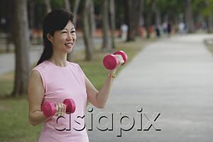 AsiaPix - Mature woman exercising with dumbbells in park
