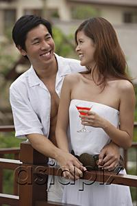 AsiaPix - Couple standing side by side on balcony, smiling at each other