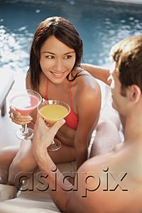 AsiaPix - Couple by swimming pool, toasting with drinks