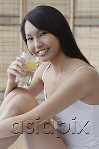 AsiaPix - Young woman drinking from glass of water