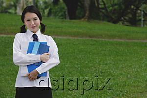 AsiaPix - Young woman in school uniform, standing in park