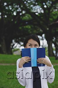 AsiaPix - Young woman in school uniform, book covering face, looking away
