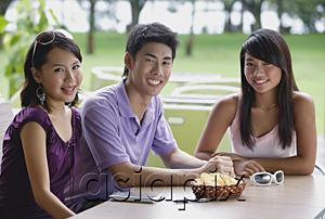 AsiaPix - Young adults sitting at outdoor cafe, smiling at camera