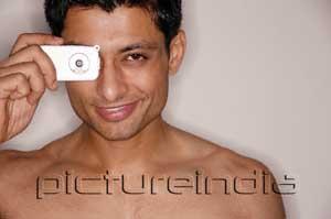 PictureIndia - Man looking through camera phone, smiling