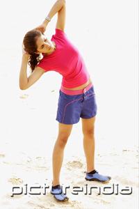 PictureIndia - Young woman at the beach, exercising