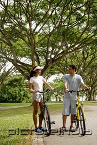 PictureIndia - Couple standing with bicycles in park