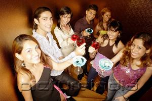 PictureIndia - Young adults raising drinks to camera