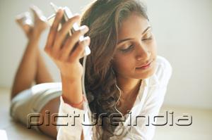 PictureIndia - Woman listening to music from MP3 player