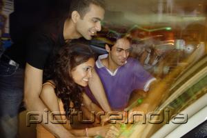 PictureIndia - Young adults in amusement arcade, playing games