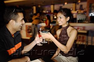 PictureIndia - Couple in a club, toasting with cocktails