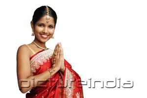 PictureIndia - Woman in traditional Indian costume standing against white background, smiling at camera