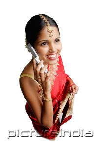 PictureIndia - Woman in sari, using mobile phone, smiling