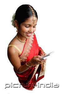PictureIndia - Woman in sari, using mobile phone, text messaging