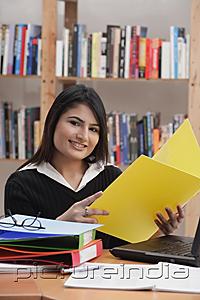PictureIndia - Woman in library, holding yellow folder