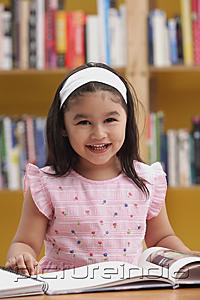 PictureIndia - Young girl reading a book, smiling at camera