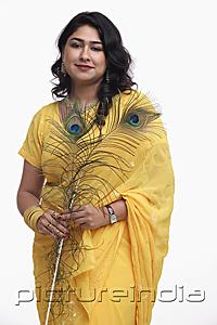 PictureIndia - Woman in yellow sari holding peacock feather
